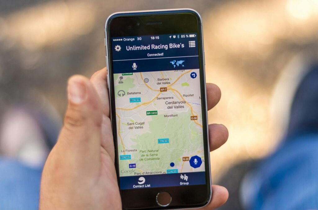 Hand holding smartphone displaying a GPS map application with location data.